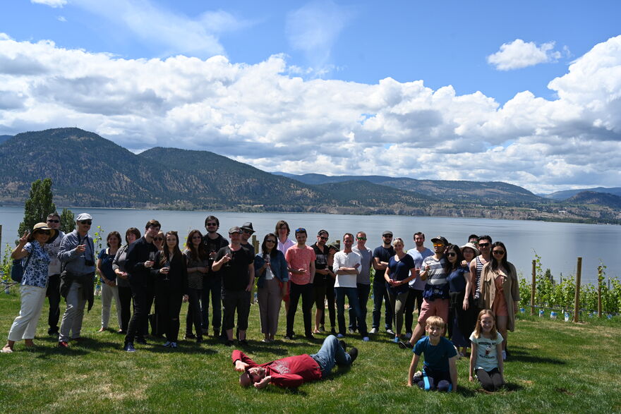Smoking gun group photo by a lake with mountains in the background