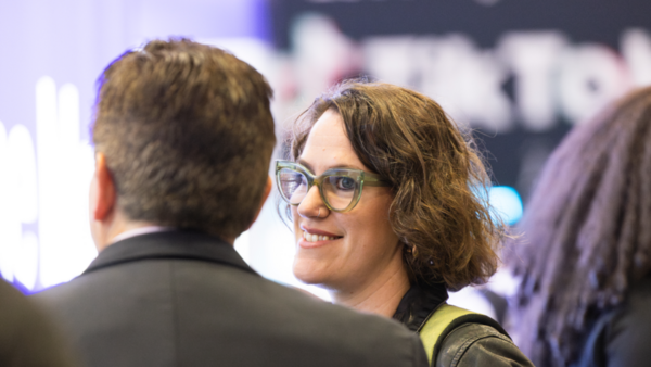 Tara Philips, Create Art Services Director smiling while talking to a man at GDC.